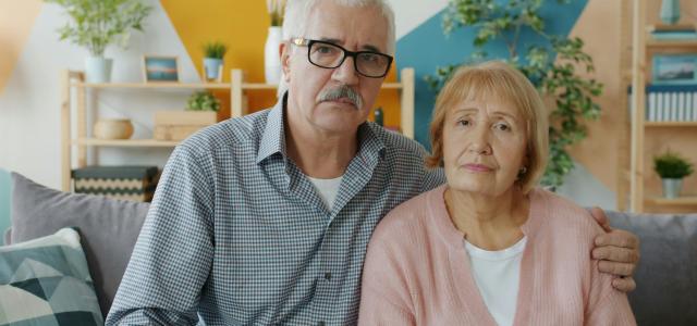 Elderly couple sitting on a couch indoors. by Vitaly Gariev courtesy of Unsplash.